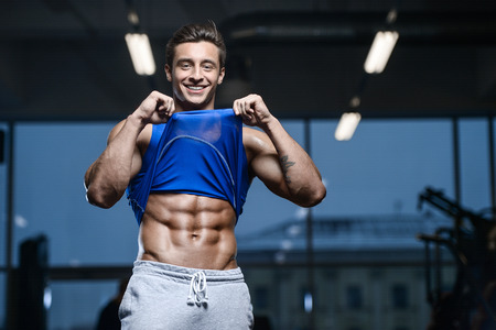 Handsome young fit muscular caucasian man of model appearance workout training in the gymの写真素材