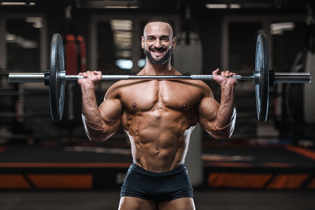 Brutal strong bodybuilder athletic man pumping up muscles workout bodybuilding concept background - muscular bodybuilder handsome men doing exercises in gym naked torso sport and diet conceptの写真素材