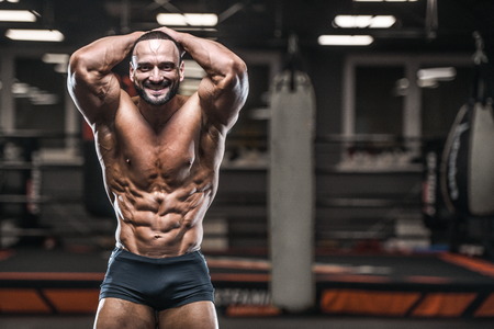 Brutal strong bodybuilder athletic man pumping up muscles workout bodybuilding concept background - muscular bodybuilder handsome men doing exercises in gym naked torso sport and diet conceptの写真素材