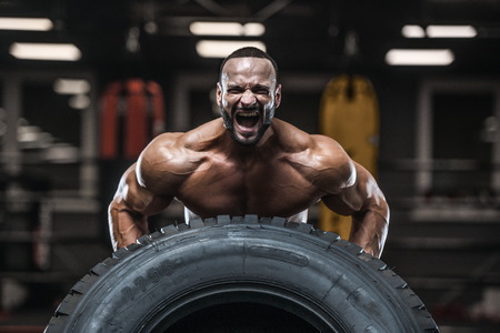 Brutal strong bodybuilder athletic man pumping up muscles workout bodybuilding concept background - muscular bodybuilder handsome men doing exercises in gym naked torso sport and diet conceptの写真素材