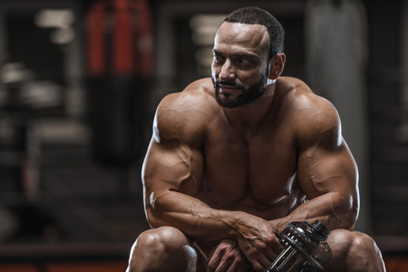 Brutal strong bodybuilder athletic man pumping up muscles workout bodybuilding concept background - muscular bodybuilder handsome men doing exercises in gym naked torso sport and diet conceptの写真素材