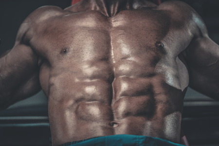 Brutal strong bodybuilder athletic aged man pumping up muscles workout bodybuilding concept background - muscular bodybuilder handsome men doing exercises in gym naked torso sport and diet conceptの写真素材
