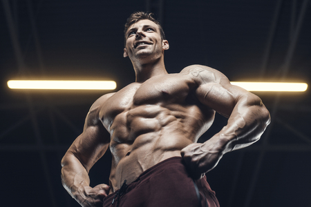 Handsome strong athletic men pumping up muscles workout bodybuilding concept background - muscular bodybuilder handsome men doing exercises in gym naked torsoの写真素材