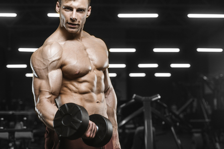 Handsome strong athletic men pumping up muscles workout barbell curl bodybuilding concept background - muscular bodybuilder men doing exercises in gym naked torsoの写真素材