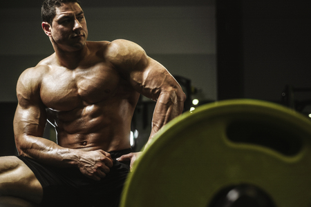 Handsome strong athletic men pumping up muscles workout bodybuilding concept background - muscular bodybuilder handsome men doing exercises in gym naked torsoの写真素材