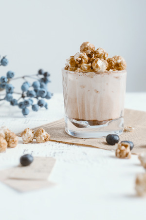 Cocoa Drink with Whipped Cream and Caramel Popcorn in Tall Glass Served in Restaurant. Cacao Milkshake, Hot Chocolate with Milk, Lavender Syrup and Marshmallowの写真素材
