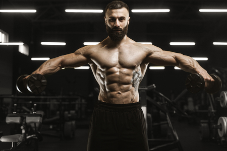 Handsome strong athletic men pumping up muscles workout bodybuilding concept background - muscular bodybuilder handsome men doing exercises in gym naked torsoの写真素材