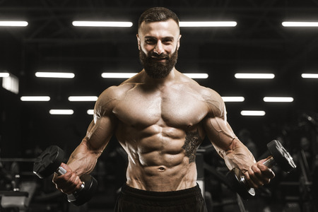 Handsome strong athletic men pumping up muscles workout barbell curl bodybuilding concept background - muscular bodybuilder men doing exercises in gym naked torsoの写真素材