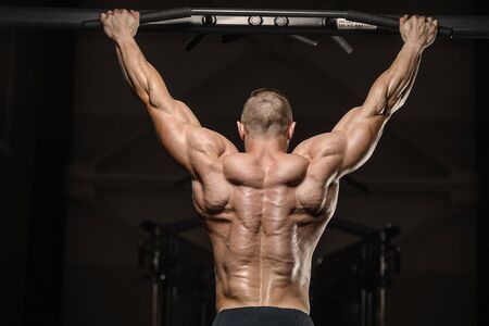 Handsome strong athletic men pumping up back muscles workout fitness and bodybuilding concept...