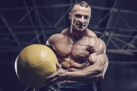 Brutal strong athletic men pumping up muscles workout bodybuilding concept background - muscular bodybuilder handsome men doing exercises in gym naked torsoの写真素材