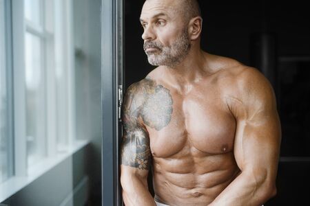 Brutal strong athletic men pumping up muscles workout bodybuilding concept background - muscular bodybuilder handsome men doing exercises in gym naked torsoの写真素材