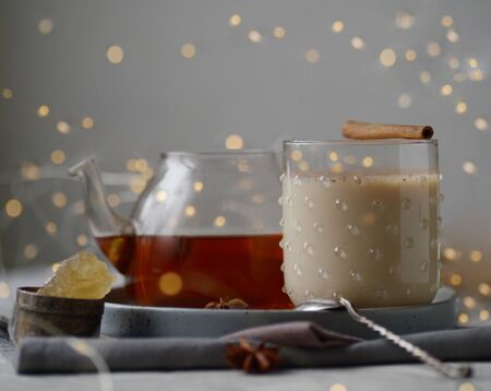 Masala warm spicy tea Indian chai warming drink with spice healthy food conception health new year Christmas decoration festoon shining glowing garland winter holidays treat ingredients componentsの写真素材