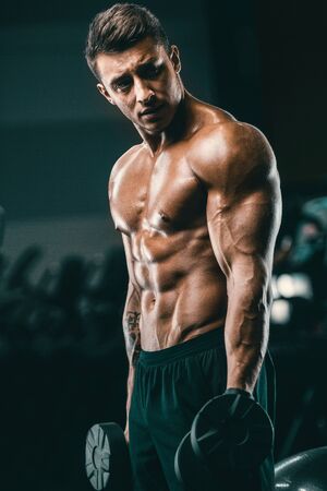 Handsome strong athletic men pumping up muscles workout fitness and bodybuilding concept background - muscular bodybuilder fitness men doing arms abs back exercises in gym naked torsoの写真素材
