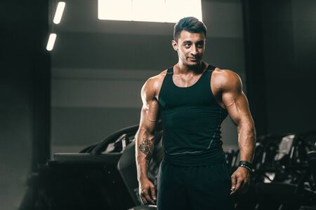 Handsome strong athletic men pumping up muscles workout fitness and bodybuilding concept background - muscular bodybuilder fitness men doing arms abs back exercises in gym naked torsoの写真素材