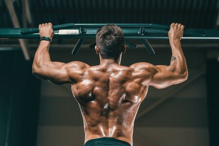 Handsome strong athletic men pumping up muscles workout fitness and bodybuilding concept background - muscular bodybuilder fitness men doing arms abs back exercises in gym naked torsoの写真素材