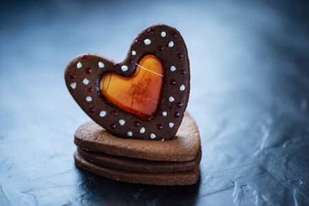 Stacked heart shaped cookies dark background isolated gluten-free caramel ginger biscuits. Saint Valentine's Day concept holiday greeting card. Romantic love dateの写真素材