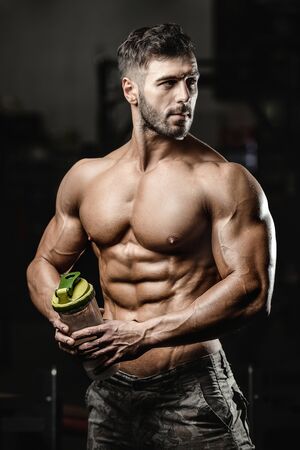 Bodybuilder handsome strong athletic rough man pumping up muscles workout fitness and bodybuilding healthy concept background - muscular fitness men doing arms exercises in gym naked torsoの写真素材