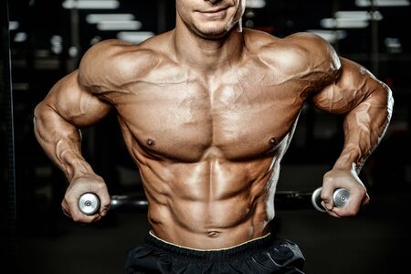Bodybuilder handsome strong athletic rough man pumping up abs muscles workout fitness and bodybuilding healthy concept background - muscular fitness men doing abdominal exercises in gym naked torsoの写真素材