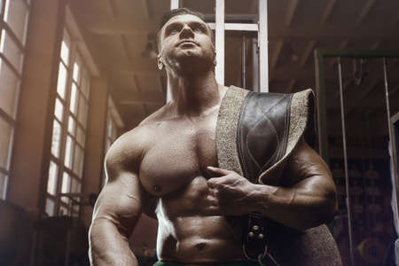 old fashion bodybuilder doing exercises in old school gym. Handsome caucasian sports man style of the 80s. Sport, fitness and workout 80s conceptの写真素材