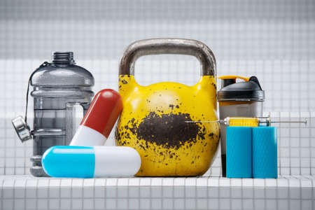 Set of sports accessories. Yellow kettlebell with pills, shaker, syringe, injector, steroids, medicine and water bottle on white background. Sport and medicine conceptの写真素材