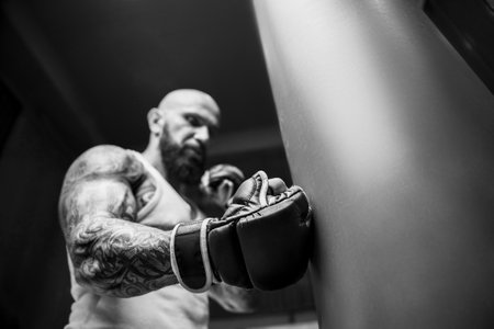 Brutal and muscular strong bodybuilder athletic man pumping up muscles at workout in the gym. Sport...