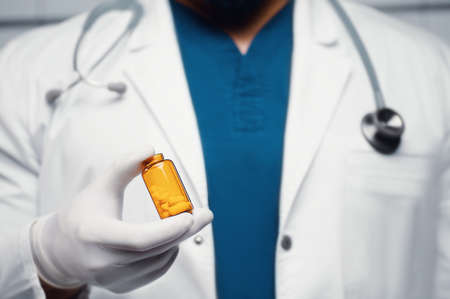 The doctor holds a bottle of pills in his hands. Health care conceptの写真素材