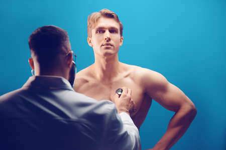 Doctor listening with stethoscope to patient in medical office. Health care conceptの写真素材
