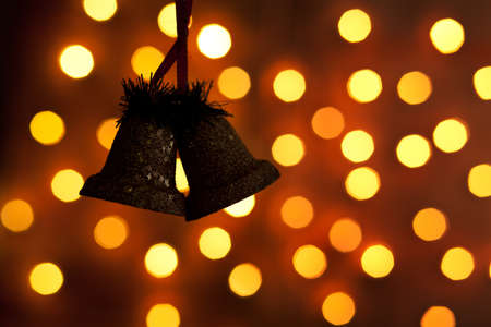 silhouette of two bells with  lights in the background の写真素材