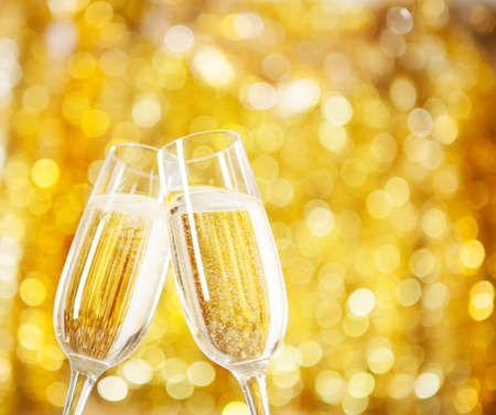Two glasses of champagne with lights in the background. very shallow depth of field, , focus on near glass.の写真素材