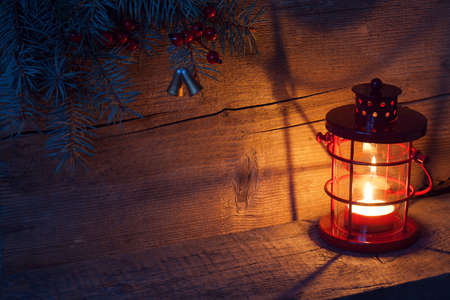 Christmas lantern in night on old wooden background.の写真素材