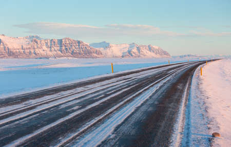 The road on a sunny winter day along  the snow-capped mountains. The Ring Road Route 1 of Iceland, between Hof and Jokulsarlon. South of Icelandの写真素材