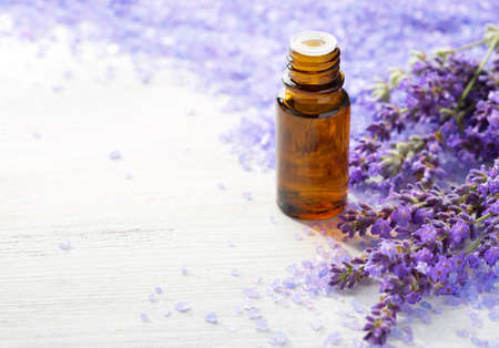 Lavender essential oil,   sprigs of lavender and  mineral bath salts on  the wooden table.  Selective focusの写真素材