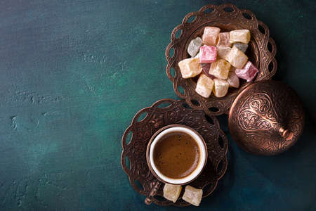 Traditional turkish coffee  and turkish delight on dark green wooden background. flat layの写真素材
