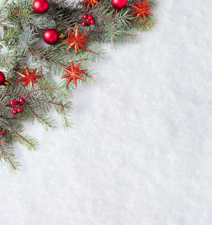 Fir branch with Christmas decorations on the background of natural snow.の写真素材