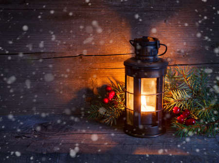 Cristmas lantern  in night on old wooden background. focus on the wick candlesの写真素材