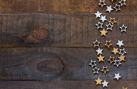Wooden  background with Christmas decorations in a rustic style. Silver and golden stars on old...