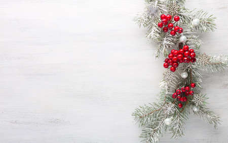 Fir branch with Christmas decoration on white shabby wooden board.  Christmas background with copy space for text. Flat lay.の写真素材