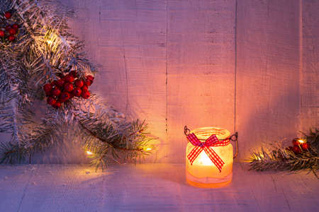 Christmas lantern and spruce branches with Christmas decorations on rustic wooden background at dusk . Toned image.の写真素材