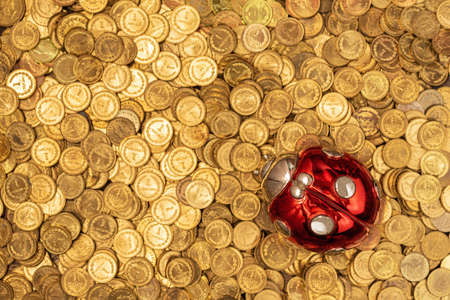 Bed of golden coins with lucky ladybug on topの写真素材
