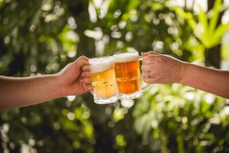 Two people toasting with mugs full of choppの写真素材