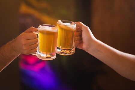 Two people toasting with mugs full of choppの写真素材