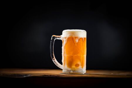 mug full of chopp, with chopp on a rustic tableの写真素材