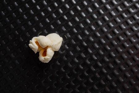 popcorn grains popped in top view, and closeup and black textured background.の写真素材