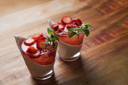 strawberry caipirinhas with ice scattered on rustic table