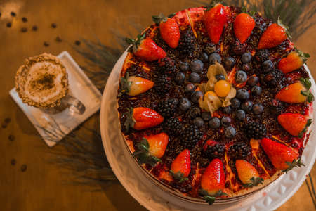 red fruits and chocolate birthday cake, wish coffee cup, selective focusの写真素材