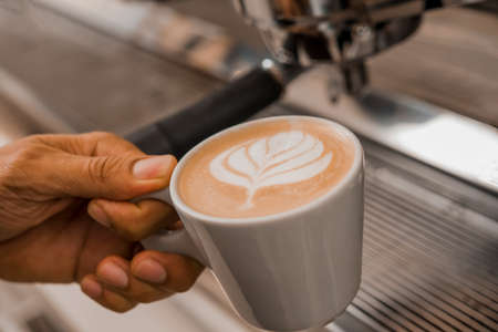 coffee latte art in a clean coffee shop with White cup and selective focusの写真素材