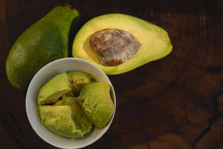 avocado butter, sliced on dark wooden background, copy space