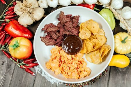 Assorted chips with sauce on a white plateの写真素材