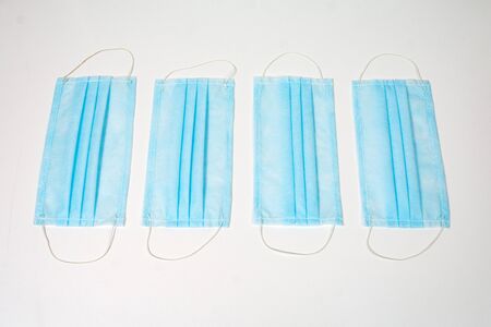 blue medical masks on a white backgroundの写真素材