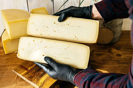 Large pieces of chopped cheese in the handsの写真素材